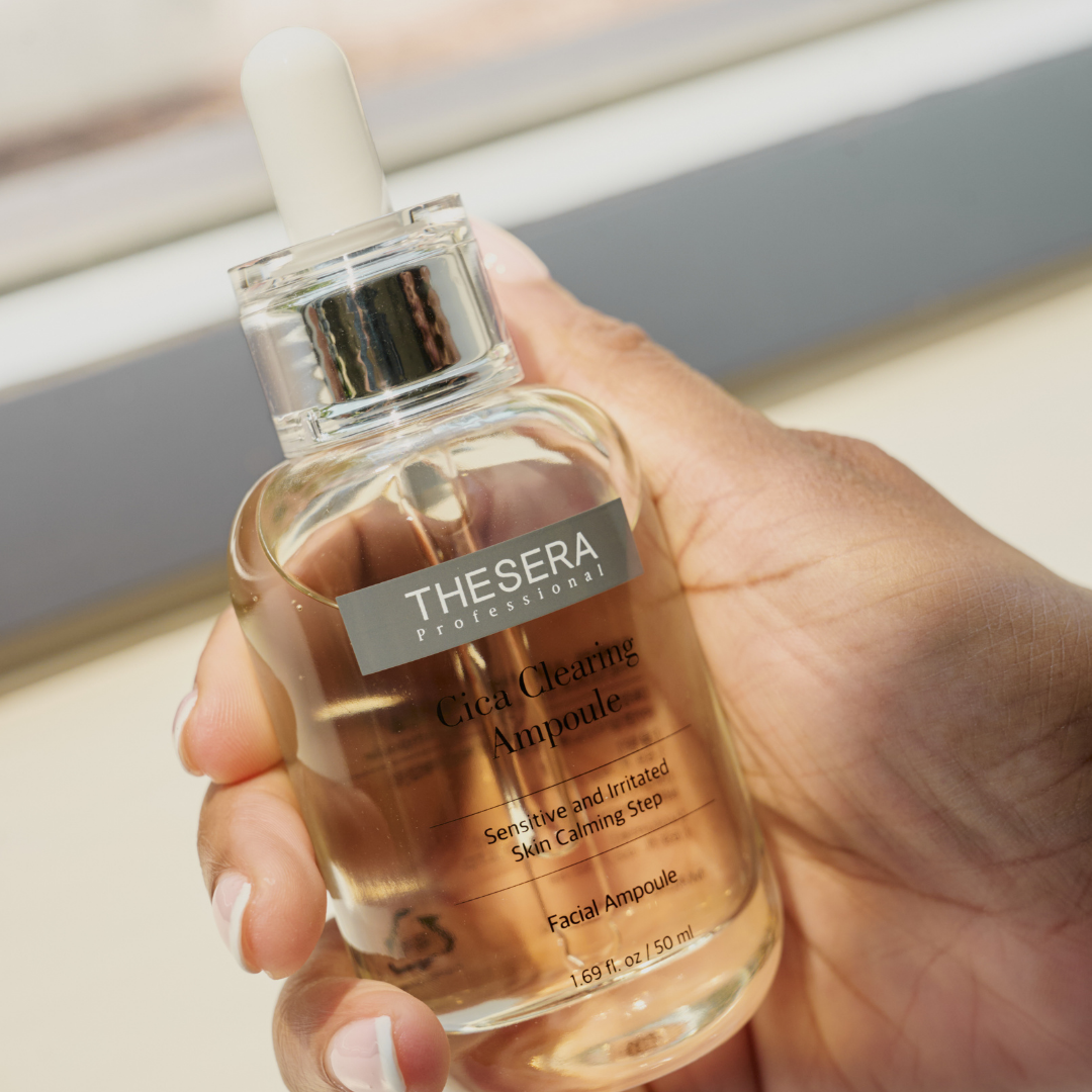 Hand holding Thesera Professional Cica Clearing Ampoule 50ml glass dropper bottle — calming serum for oily and congested skin
