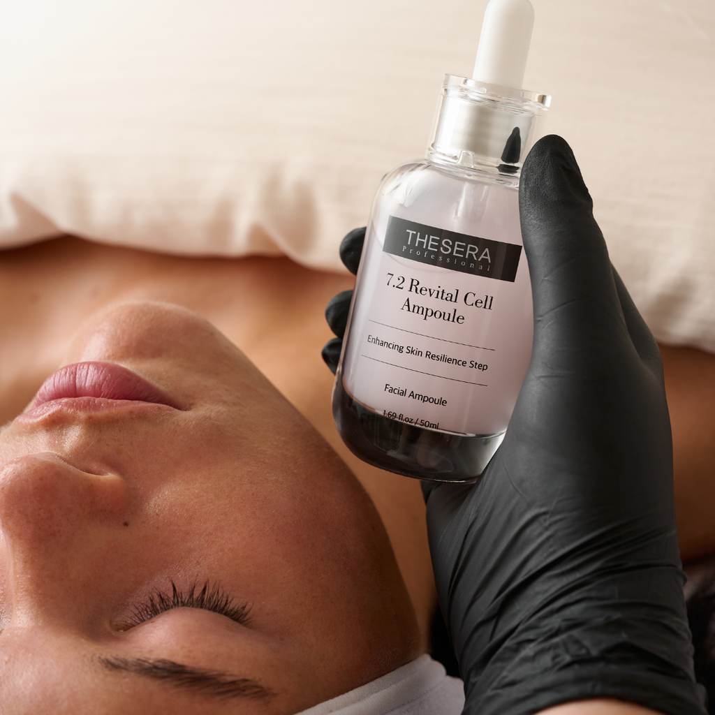 Esthetician in black gloves holding Thesera Professional 7.2 Revital Cell Ampoule 50ml beside a client receiving a facial treatment — rejuvenating serum for skin renewal and vitality